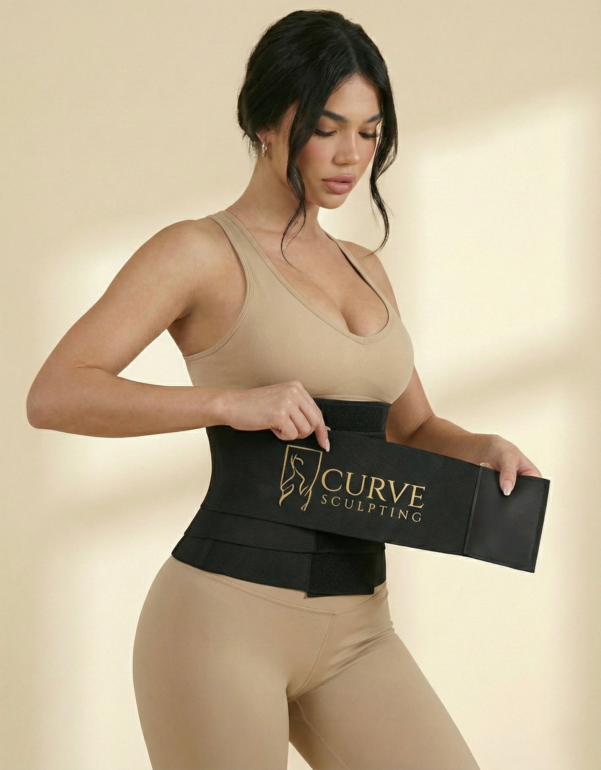 Woman putting on the Curve Sculpting 4 metre postpartum belly wrap